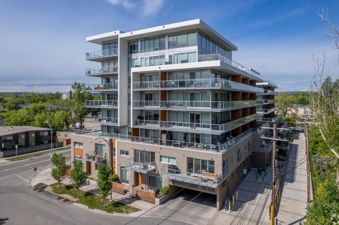 Modern multi-storey condominium building with balconies and exterior ledges requiring pigeon prevention.